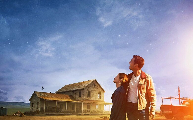Man and young girl gazing up at a starry sky beside a weathered two-story farmhouse